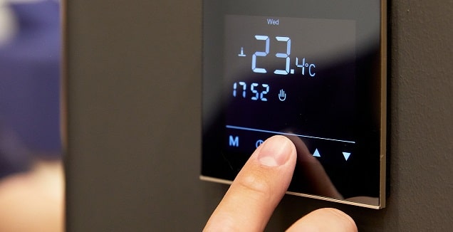 main sur un thermostat pour éteindre le chauffage