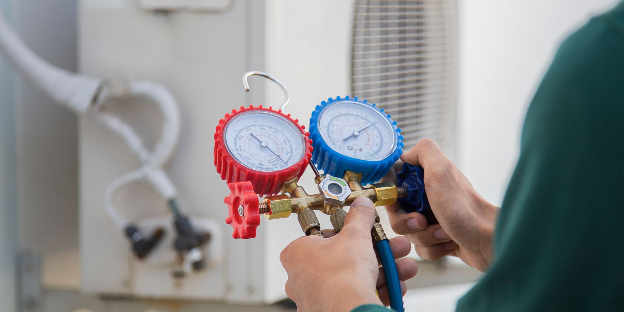 Technicien contrôlant la pression d’une pompe à chaleur pour réparer une pression trop haute