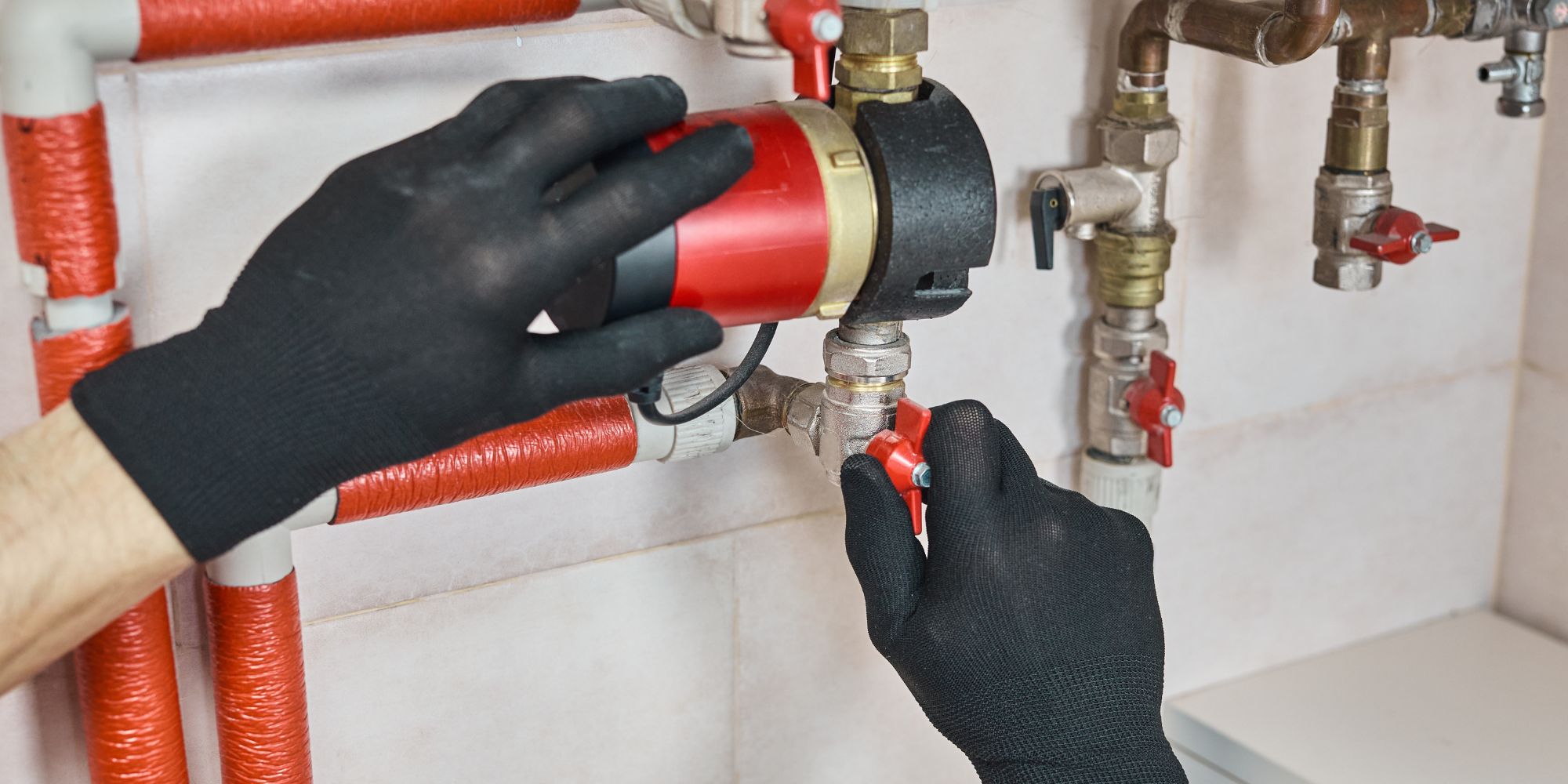 Technicien manipulant une pompe de circulation sur circuit de chauffage – diagnostic en cours après symptôme de circulateur de chaudière HS