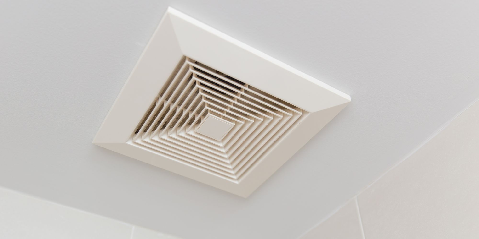 bouche de VMC installé sur le plafond d'une salle de bain pour illustrer la question de l'obligation de ventilation dans le contexte de location d'un logement