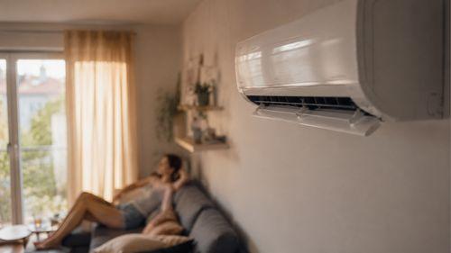 Climatisation murale en fonctionnement en mode froid dans un appartement pendant une journée d'été chaude