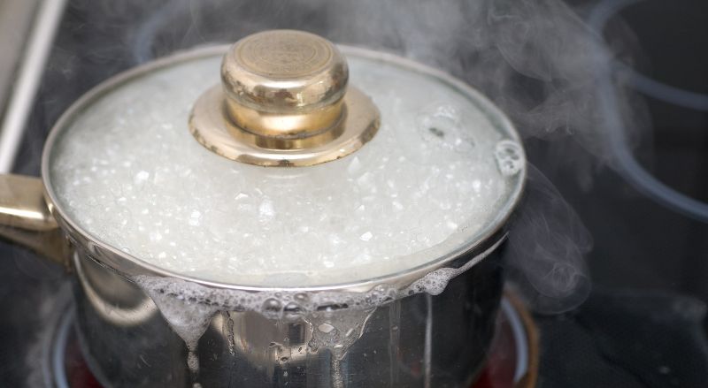 Casserole d'eau bouillante en train de deborder sur une plaque a induction