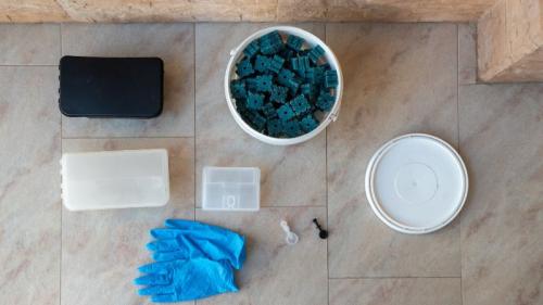 Matériel de dératisation disposé au sol : gants, appâts rodenticides, boîtes sécurisées – illustration de comment se passe une dératisation