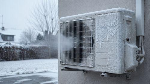 Unité extérieure de climatisation réversible givrée, illustrant une hausse de la consommation lorsque le climatiseur est en mode chaud par grand froid