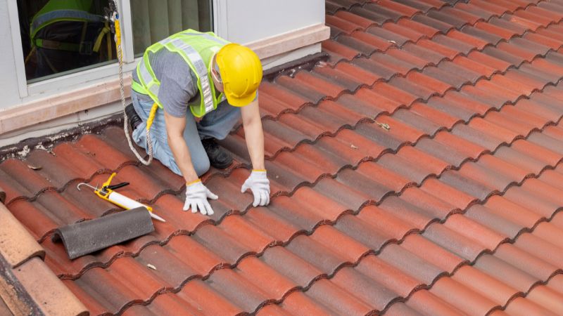 Couvreur en train de refaire des joints sur la toiture