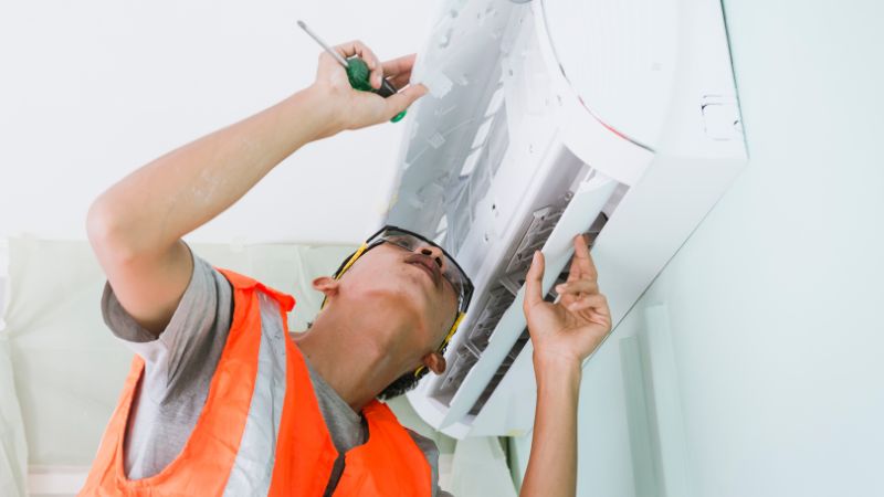 Professionnel en train de réaliser l'entretien d'une clim