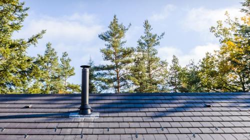 sortie de poele à bois sur un toit pour illustrer l'importance de l'installation du conduit lorsqu'il y a un problème de refoulement de la fumée