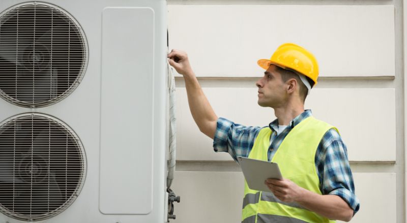 technicien en train de regler une pac lors de son installation ou de la reparer