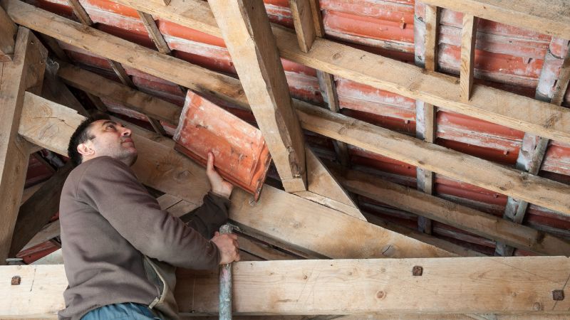 Un professionnel inspectant les combles, première étape d'une recherche de fuite sur toiture