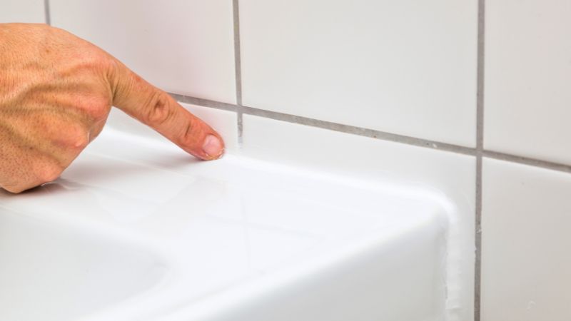 L'une des étapes délicates pour refaire un joint silicone : le lissage. Ici on voit un doigt nu lissant le joint pour un résultat peu uniforme