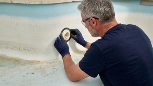 réparation de fuite de piscine avec un professionnel démontant la buse de refoulement pour changer le joint