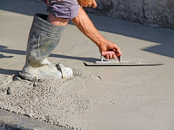 Maçon qui taloche une dalle béton