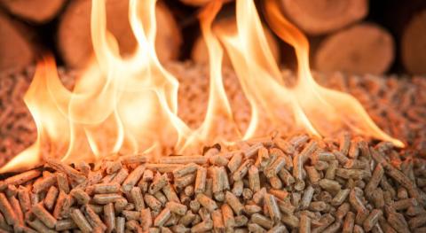 granules en train de bruler avec de grandes flammes et en arriere plan buches de bois