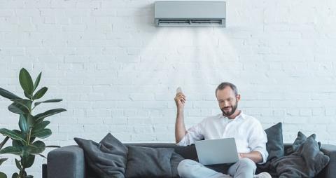 Homme calculant la consommation horaire de son climatiseur