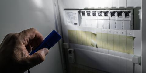 Personne qui examine son tableau électrique