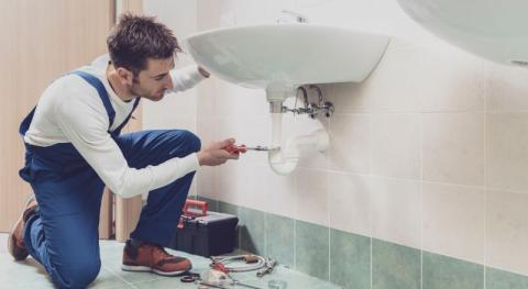 plombier installant un lavabo suspendu 
