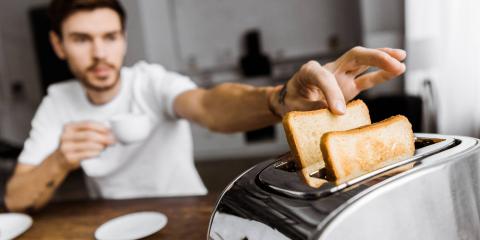 personne qui attrape des toasts dans un grille-pain