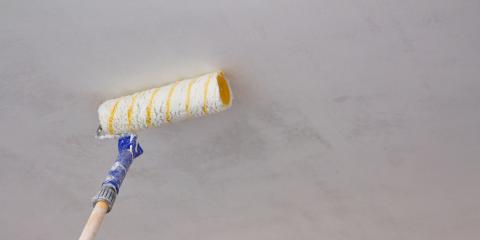 Personne qui peint un plafond avec un rouleau.