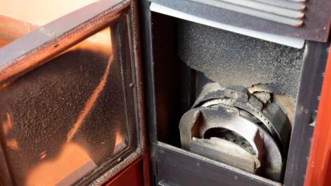 vitre d un poele a granules noircie et chambre de combustion pleine de suie