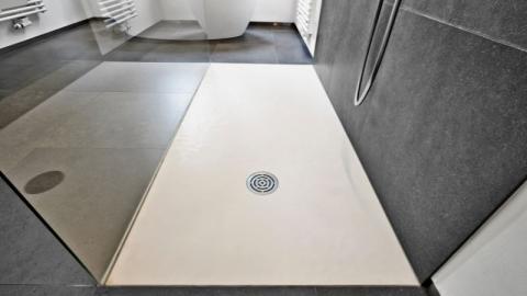 gros plan sur un receveur de douche plat dans une salle de bain moderne grise