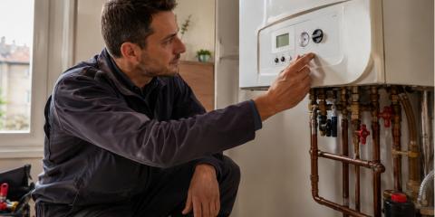 Technicien chauffagiste vérifiant la pression d'eau chaude sur une chaudière à gaz