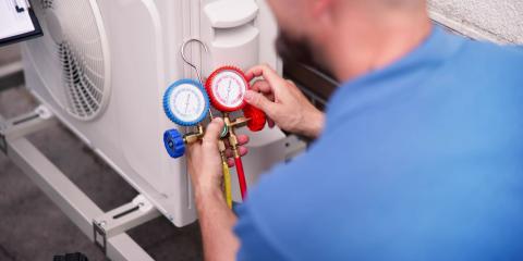 Technicien contrôlant les pressions d’une pompe à chaleur avec un manifold – intervention liée à la recharge en gaz