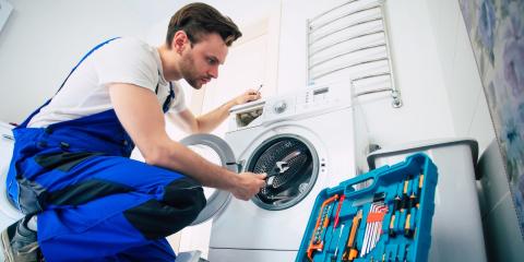 un technicien répare une machine à laver