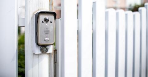 Interphone vidéo posé sur un mur vertical au niveau d'un portail