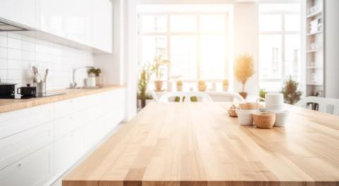 plateau de table vide en bois clair dans une cuisine blanche moderne ouverte sur un salon avec grandes fenetres