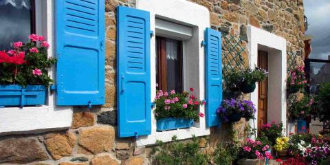volets bleus sur une maison en pierre
